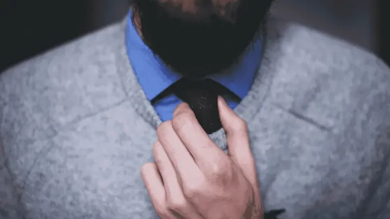 Mężczyzna trzymający sięza krawat