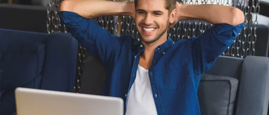 Uśmiechnięty mężczyzna przed laptopem